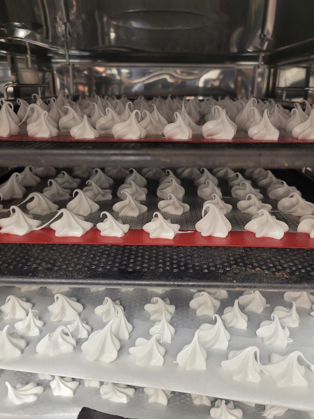 Des plaques de meringues en préparation dans la cuisine